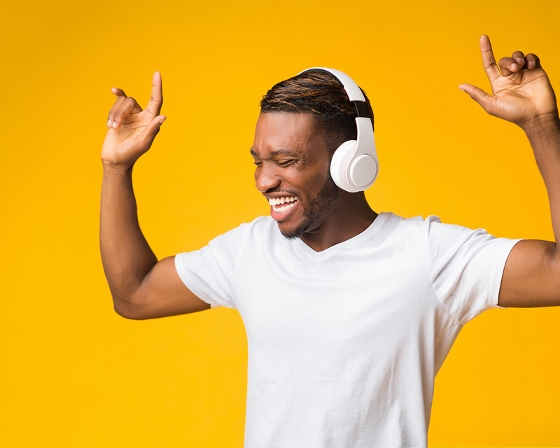 Man with headphones on dancing with hands in the air